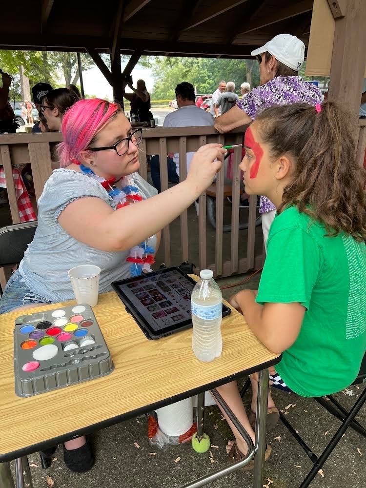 A young parishioner awaits the finishing touches in a face painting session by Kyrsten Napolitano at the annual St. Patrick’s parish, Yorktown Heights, picnic July 17 at Downing Park, Yorktown Heights.